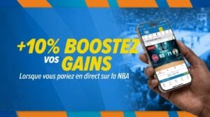 Une personne tenant un téléphone portable à la main, sur lequel est ouverte l'application Guinée Games, en train de suivre un match de la NBA en direct